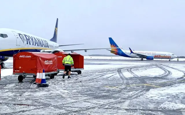 A Ryanair and a Jet2 plane on the snow-covered apron at Newcastle Airport.