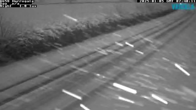 A black and white image of a snowy road