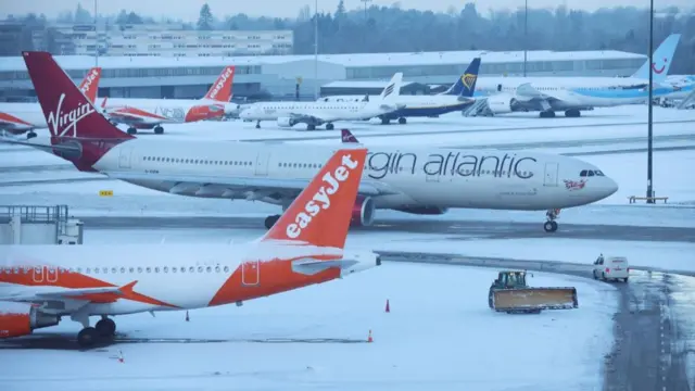 Archive shot of snow ploughs clear snow from the airfield after overnight snow forced the closure of Manchester airport in 2023