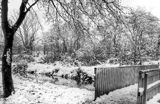 Snow on a footbridge over a stream