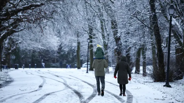 People walk in the snow at Sefton Park in Liverpool