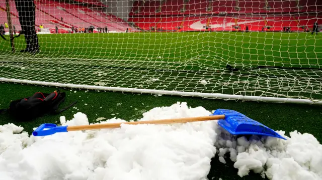 shovel of snow in goal at Anfield