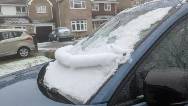 Snow rolling off a car windscreen