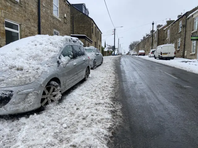 Cars covered in snow and parked on Front Street in Stanley