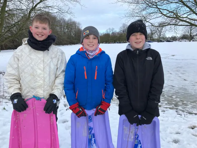 Harry, 12, James, 12 and Samson, 13, all pose on The Stray with their brightly coloured sledges