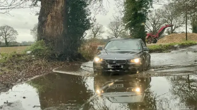 A car driving through a flooded road