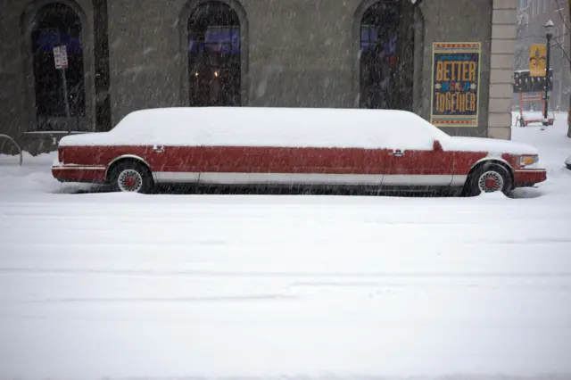 A snow-covered stretch limousine sits parked in downtown Louisville, Kentucky