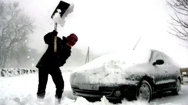 A man digs his car out from heavy snow