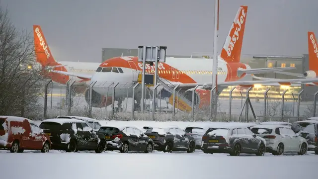 Easyjet aeroplane at John Lennon Airport, in front is a car park with cars covered in snow