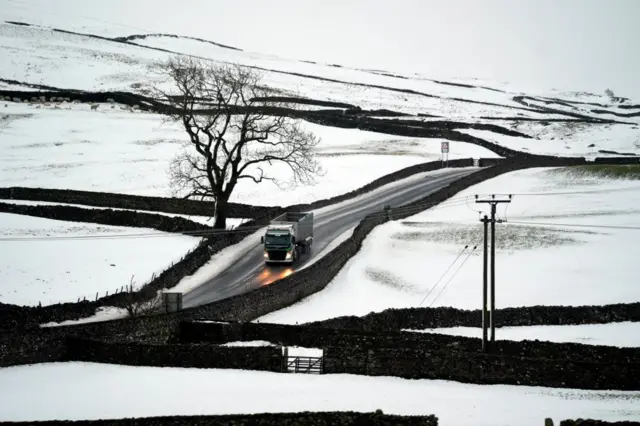 Lorry driving through snowy fields