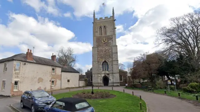 The exterior of a stone church with a large tower