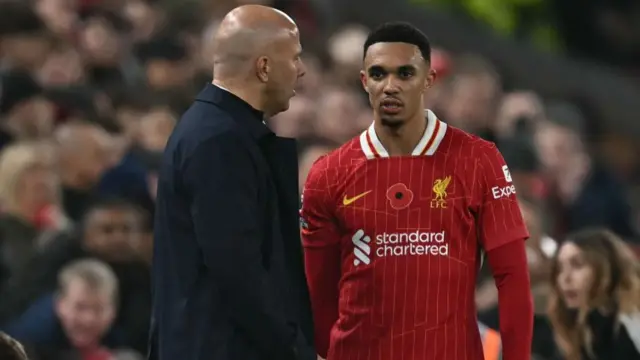 Arne Slot speaks with Liverpool defender Trent Alexander-Arnold