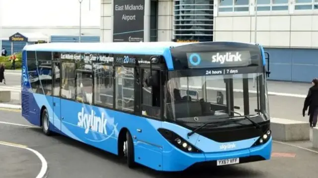 A blue bus outside East Midlands Airport Terminal