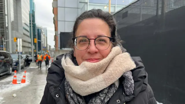 Marise Cassivi smiles to camera for her photo. She is standing on the pavement and wrapped up warm