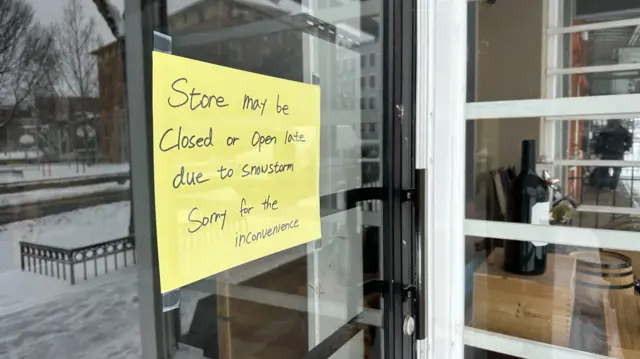 A sign says a store is closed due to the snowstorm