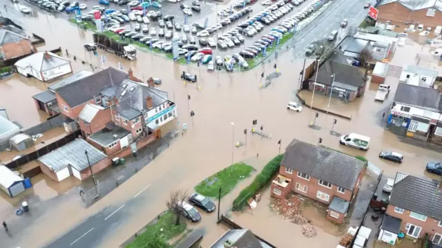 An aerial picture of flooding at a crossroads with some vehicle in the water