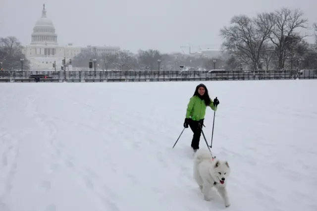 A woman skies with her dog in front of the US Capitol building in Washington DC. Photo: 6 January 2025