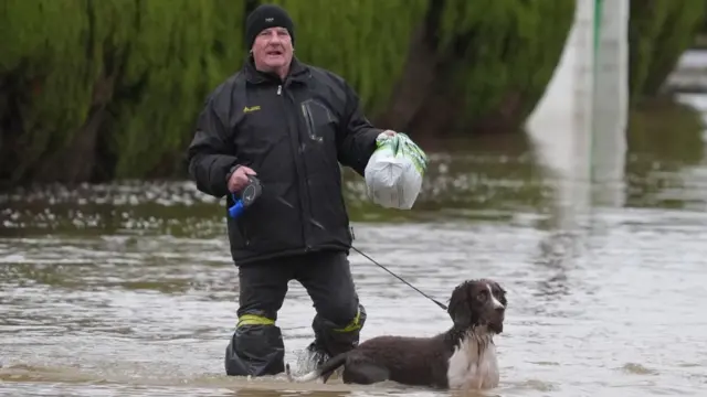 Man walking his dog in flood water