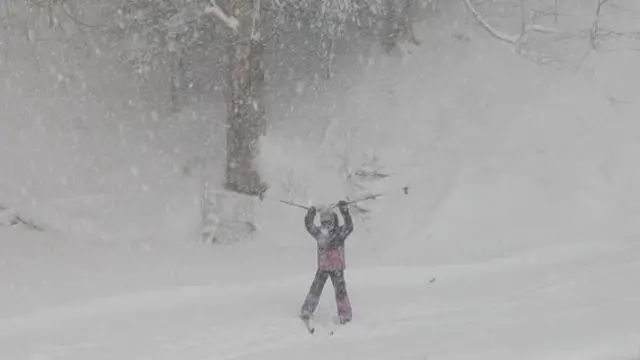 A child skiing in a blizzard