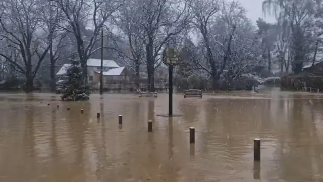 Brown floodwater covers a park