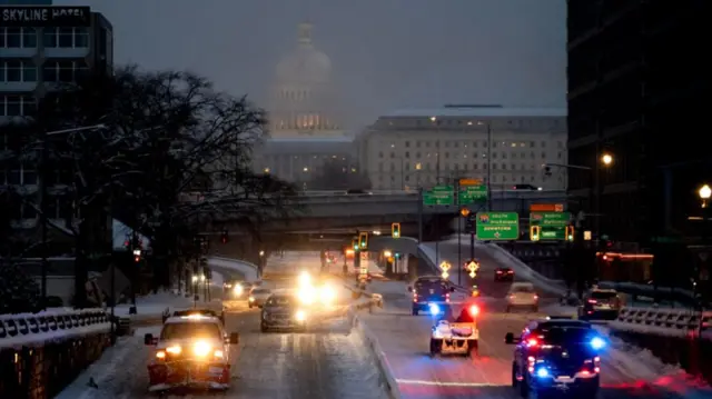 A snow plough and police vehicles are seen near the US Capitol