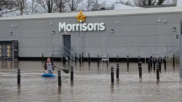 Shawna Mann floating on a paddleboard in front of Morrisons in Glenfield