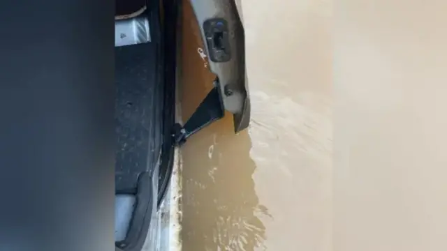 Flood water over flowing into car