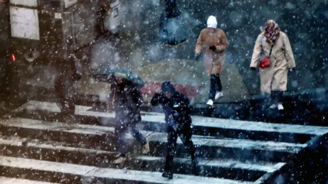 People walk through snow, down steps in Washington