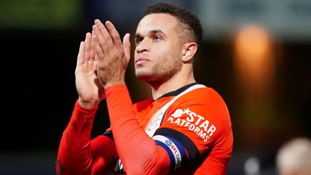 Luton striker Carlton Morris claps the travelling support at Loftus Road