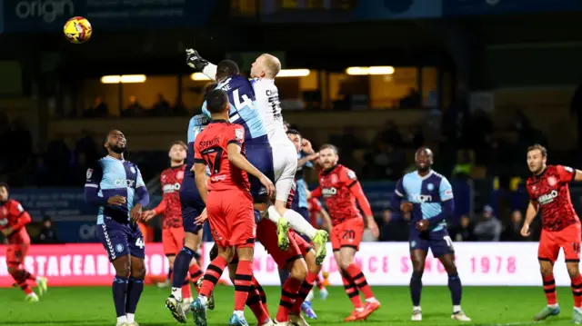 Huddersfield keeper Jacob Chapman punches clear under pressure from Wycombe's Richard Kone