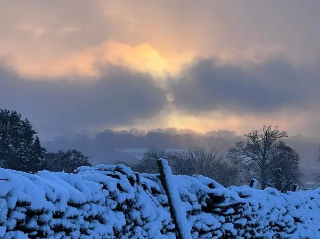 Ominous skies over a snowy wall