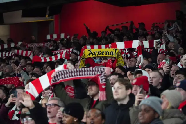 Arsenal fans holding up scarves