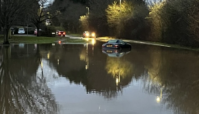 A car is submerged in flood water along a country road in Quorn, Loughborough