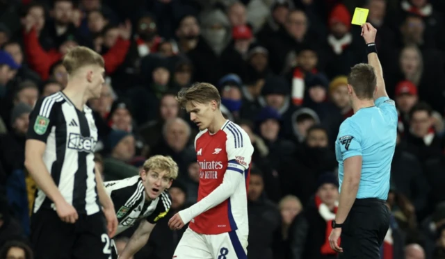 Newcastle United's Anthony Gordon is booked by referee John Brooks