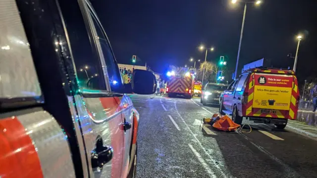 An image of emergency vehicles in the middle of a road.