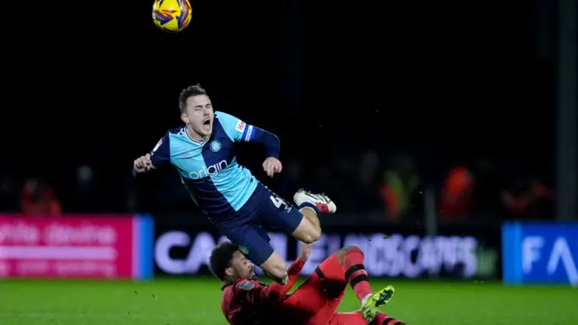 Huddersfield's Josh Koroma sends Wycombe's Josh Scowen into the air with a late challenge