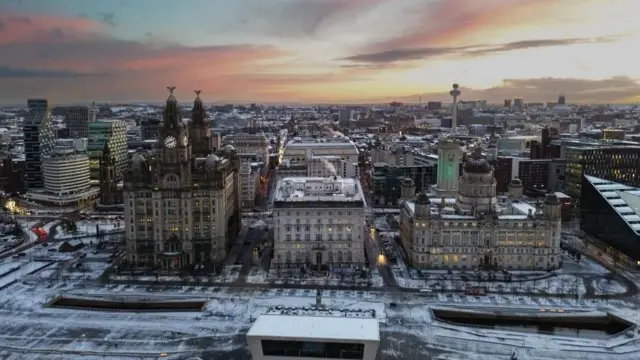 An aerial photograph taken by drone showing snow on the ground surrounding the Royal Liver Building in Liverpool