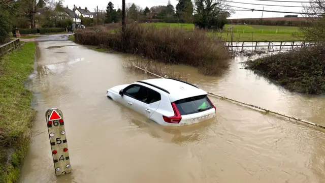 General view of car stranded in flood waters, Essex