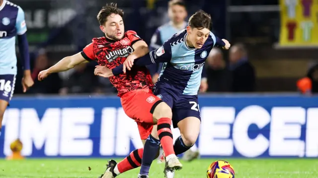 Joe Hodge of Huddersfield Town tackles Wycombe's Cameron Humphreys