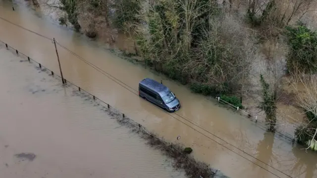 A van is stranded after driving through muddy flood water in Yalding, Kent.