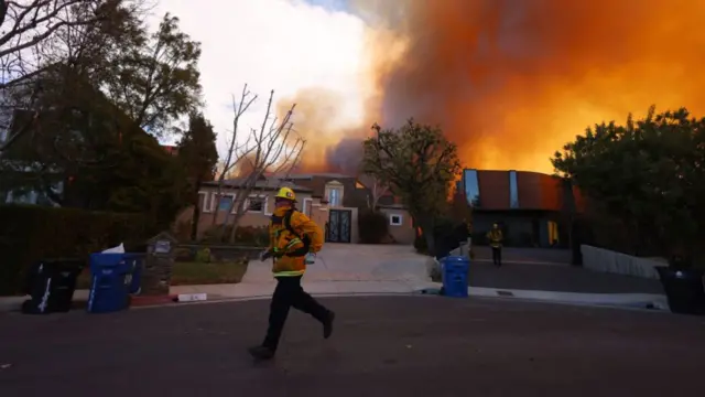 Firefighters run to save homes from burning