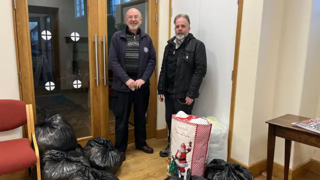 Church representatives with donations of bedding in the hall