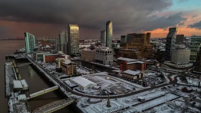 An aerial photograph taken by drone showing snow on the ground surrounding Pier Head in Liverpool