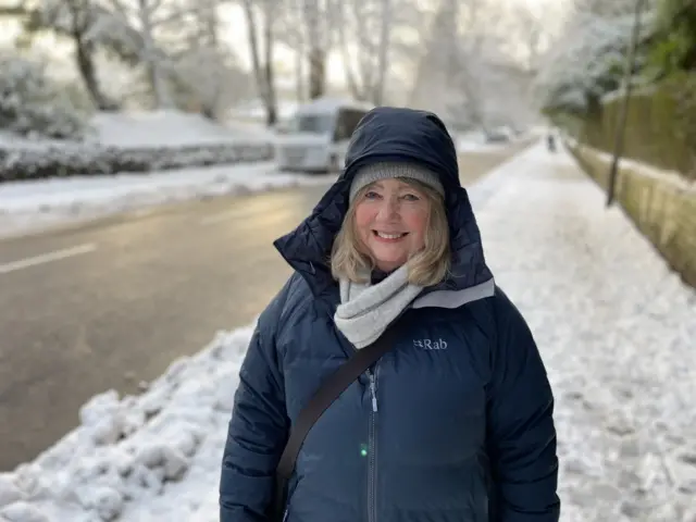 A woman wrapped up for the cold on a snowy street