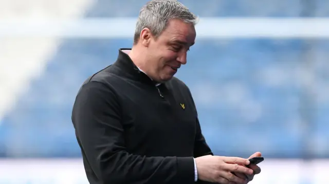 Huddersfield manager Michael Duff checks his phone