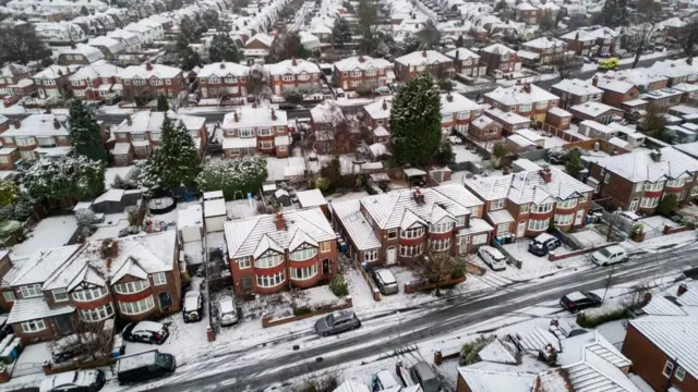 Drone footage showing snow covering rooftops of houses in Manchester