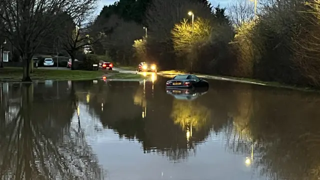 A stricken car in deep floodwater