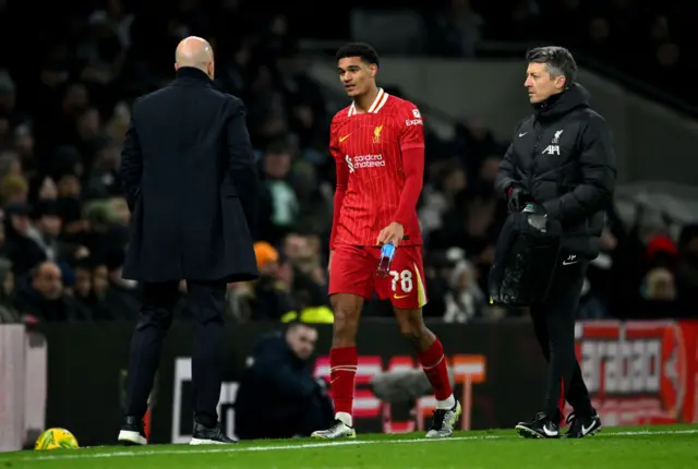 Jarell Quansah of Liverpool speaks to Arne Slot, Manager of Liverpool, as he is substituted