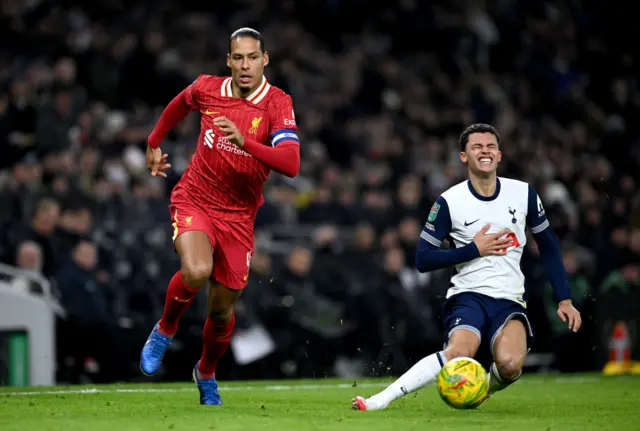 Brennan Johnson of Tottenham Hotspur goes down as he runs for the ball under pressure from Virgil van Dijk