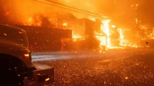 Embers flying as houses burn along a road